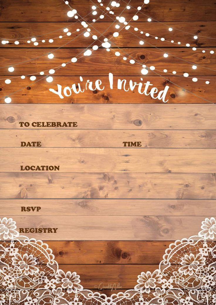 the wedding stationery is displayed on a wooden background with string lights and white lace