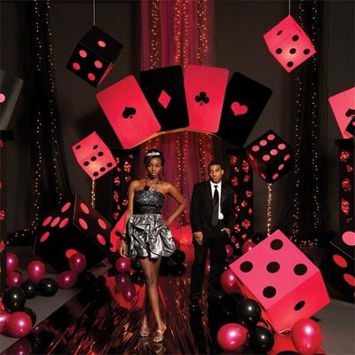 a woman standing in front of a red and black backdrop with dices on it