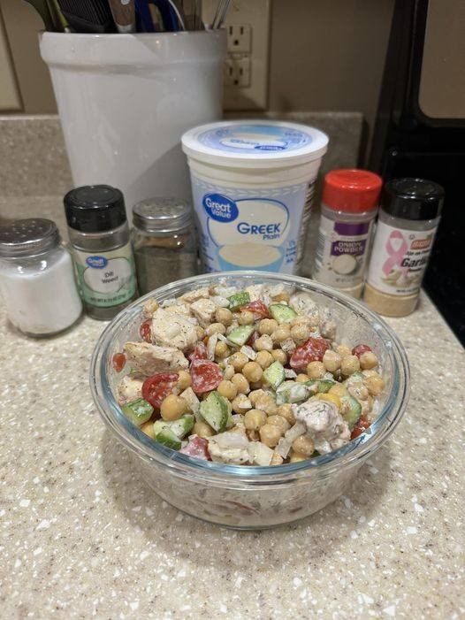 a bowl filled with food sitting on top of a counter next to some spices and condiments