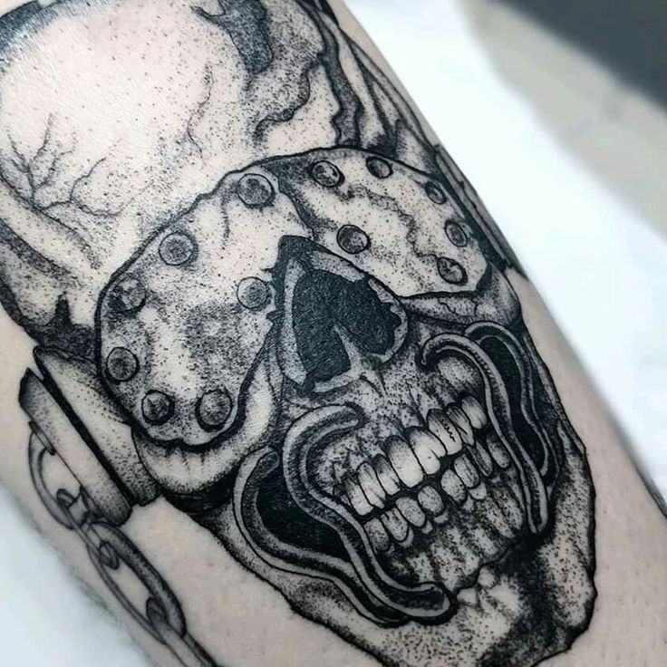 a black and white photo of a skull on the arm