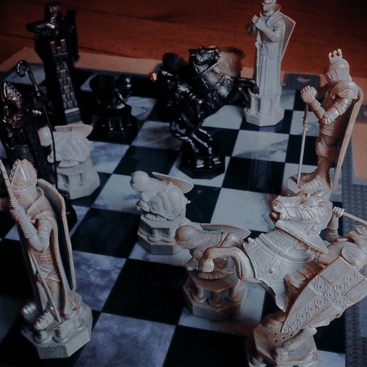 a chess board with some statues on it