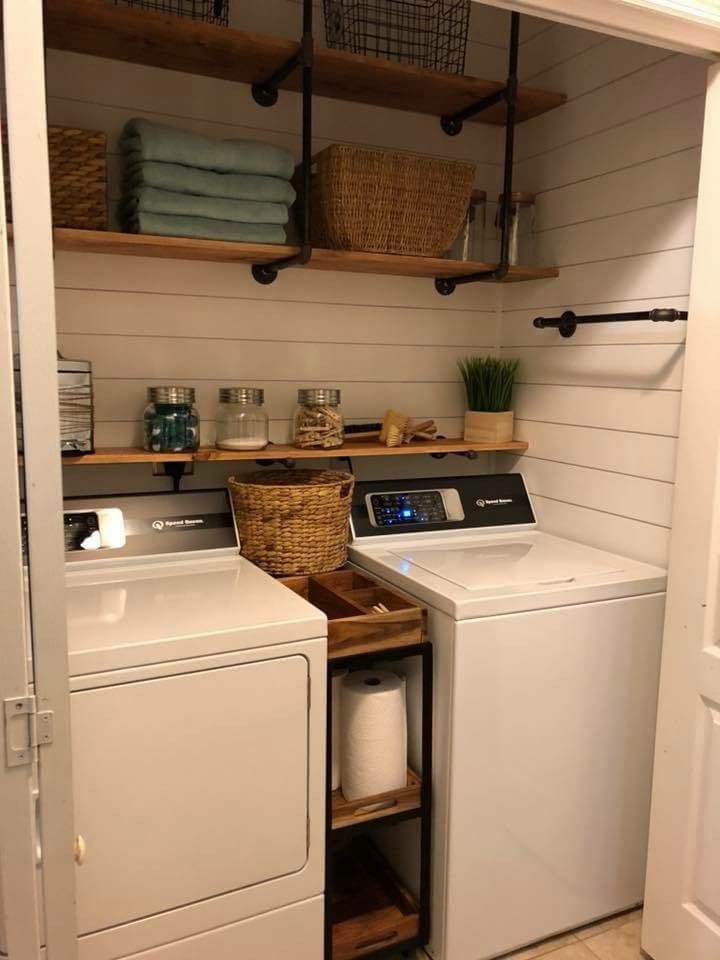 a washer and dryer in a small laundry room with open shelving on the wall