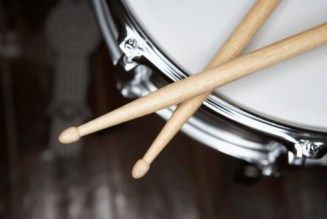 two drums sticks sticking out of the top of a drum