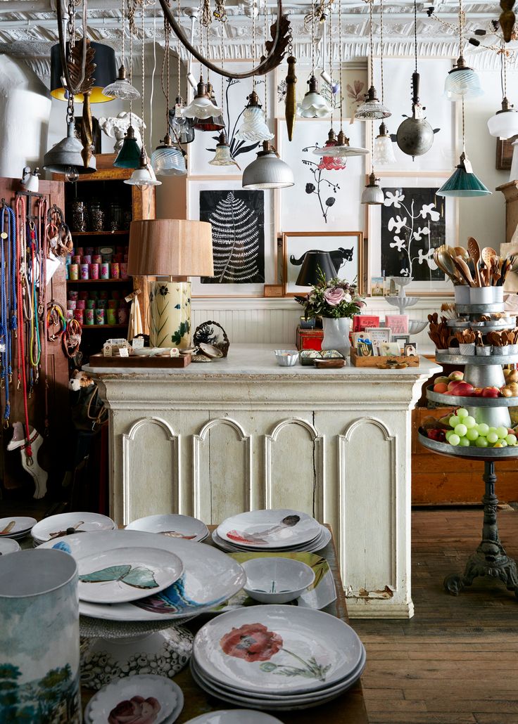 a room filled with lots of plates and hanging lights