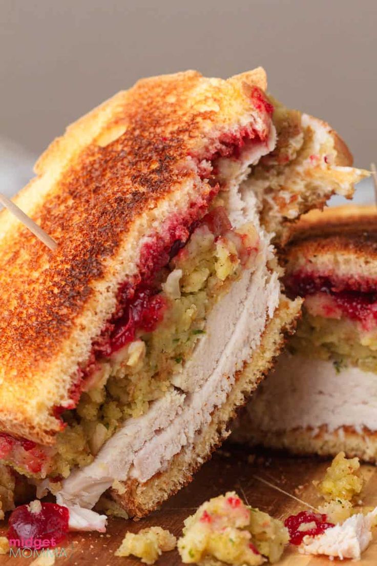 a cut in half sandwich sitting on top of a cutting board