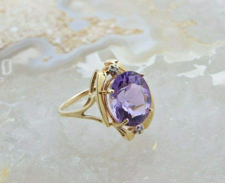 "14K Yellow Gold Attractive Modernist Bypass Amethyst and Diamond Accent Ring, medium deep amethyst oval faceted center, 14x11.5mm, 2 round diamond accents, .75\" across top, sits 3/8\" above finer, Circa 1980, Ring size 8, 5.29 grams Stock # BB185R02 Most rings are sizable for a small fee. If the ring you are considering is the incorrect size contact us for a quote. This listing contains photographs of the actual item you will receive. Our items are in excellent condition with little or no sign Gold Coin Ring, Amethyst Gem, Coin Ring, Purple Band, Fine Jewelry Designers, Yellow Gold Earring, Oval Diamond, Earring Backs, Round Diamond