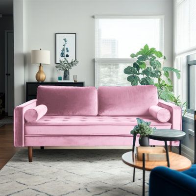 a living room filled with furniture and a pink couch