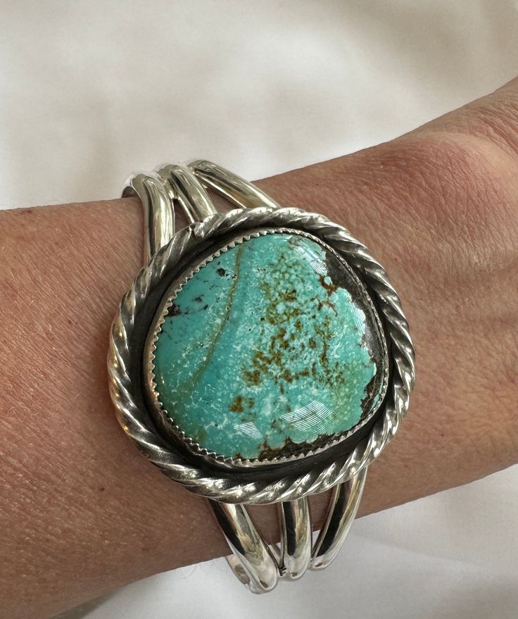 Bamboo Mountain Turquoise Cuff. Gorgeous Bamboo mountain turquoise cuff with colors from green to blue. Rare. One of a Kind Fits wrist from 6.5 -7”. Stretch to size Material: Sterling Silver Stone: Bamboo Mountian Turquoise. Stone alone is 1 1/4" You will receive the bracelet shown in the picture Luxury Artisan Turquoise Cuff Bracelet, Untreated Turquoise Artisan Cuff Bracelet, Southwestern Style Turquoise Cuff Bracelet, Southwestern Style Round Turquoise Cuff Bracelet, Artisan Round Turquoise Cuff Bracelet, Handmade Southwestern Green Cuff Bracelet, Unique Green Gemstone Cuff Bracelet, Green To Blue, Turquoise Cuff