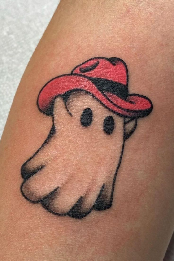 a tattoo with a ghost wearing a red hat