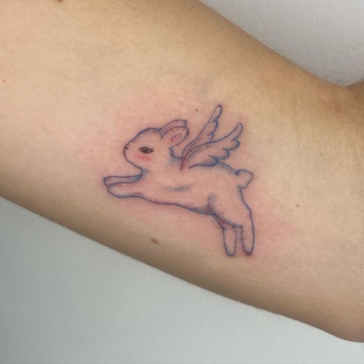 a small tattoo on the arm of a person with a rabbit in it's lap