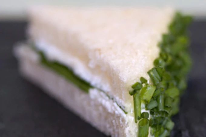 a sandwich with lettuce and cheese on it sitting on a black table top