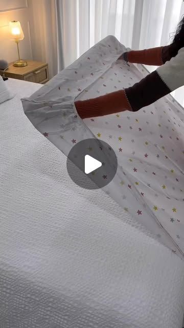 a woman unpacking a white bed with stars on it