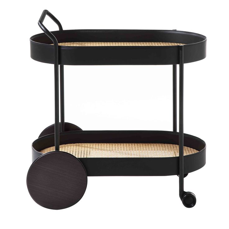 a black serving cart with two trays on wheels and wicker handles, one holding a