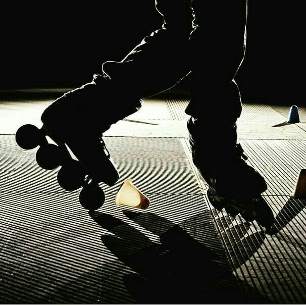 a person riding a skateboard on top of a tiled floor next to a cone