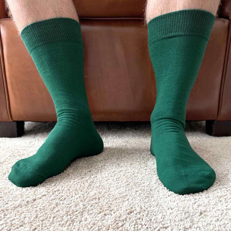 Coordinate your look from head to toe with a pair of men's hunter green socks. These dark green dress socks are a solid color style with a smooth finish. They're a crew height, so they reach to about the low to mid calf, depending on the man. These are great socks to wear for formal events like weddings, but they are a unique and stylish color to add to your business attire. (Try them with a gray, navy blue or classic black suit.) These socks can be worn casually for everyday looks, as well. You Green Cotton Winter Socks, Casual Mid-calf Green Socks, Casual Green Mid-calf Socks, Green Mid-calf Casual Socks, Fitted Mid-calf Solid Color Socks, Classic Solid Winter Socks, Solid Color Fitted Casual Socks, Classic Winter Socks, Green Stretch Cotton Socks