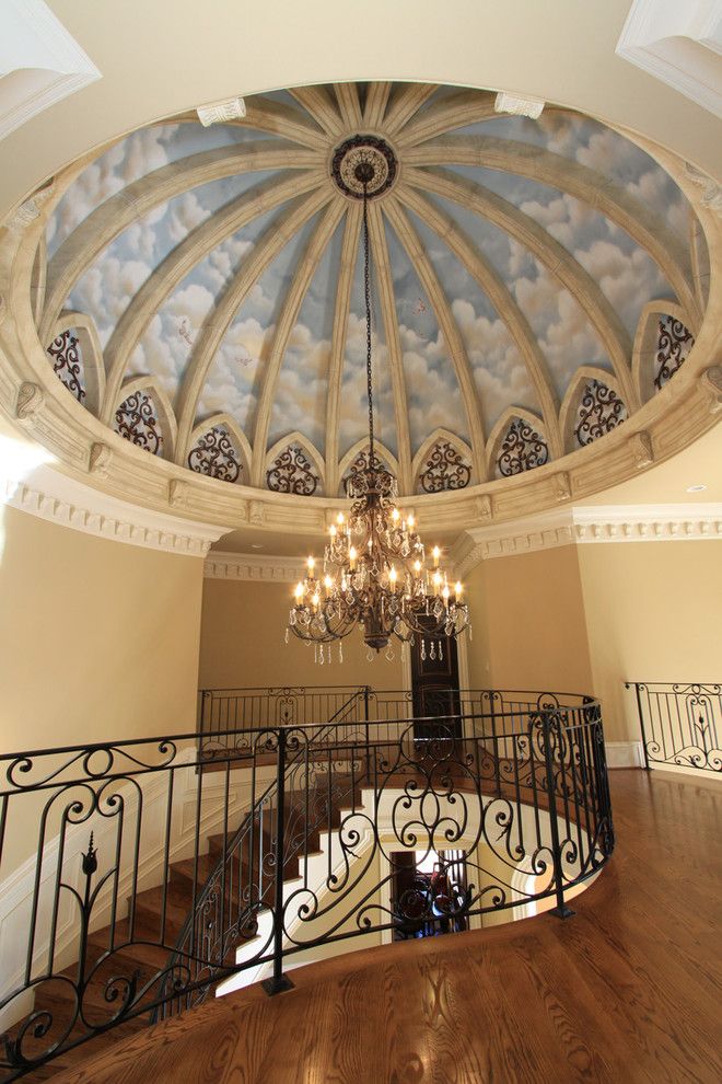 an ornate chandelier hangs from the ceiling above a spiral staircase in a home