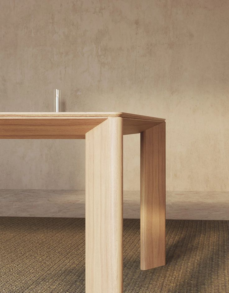 a wooden table sitting on top of a carpeted floor next to a white wall