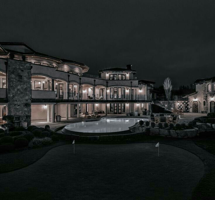 a large mansion lit up at night with lights on