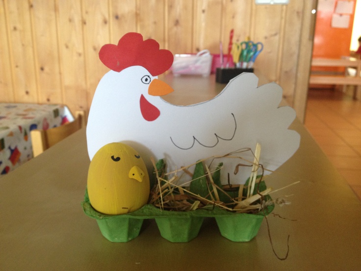 a paper chicken and egg sitting on top of an egg carton