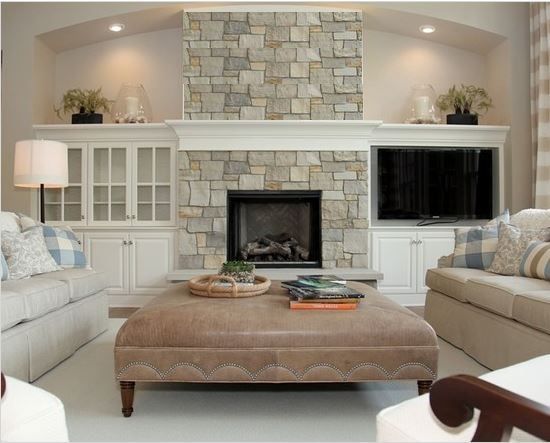 a living room filled with furniture and a fire place under a tv mounted above a fireplace