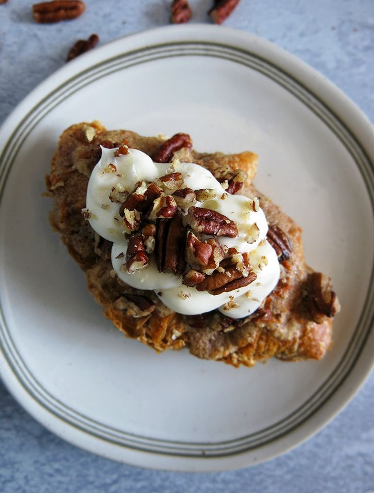 a piece of cake on a plate topped with whipped cream and pecanskin toppings