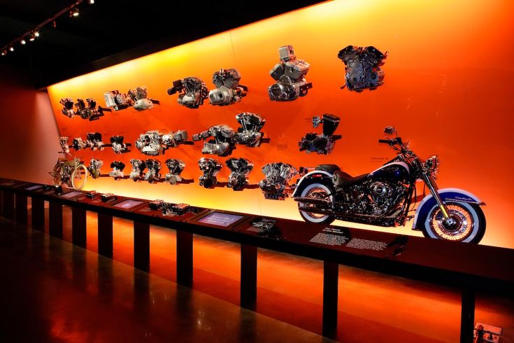 a motorcycle on display in front of an orange wall