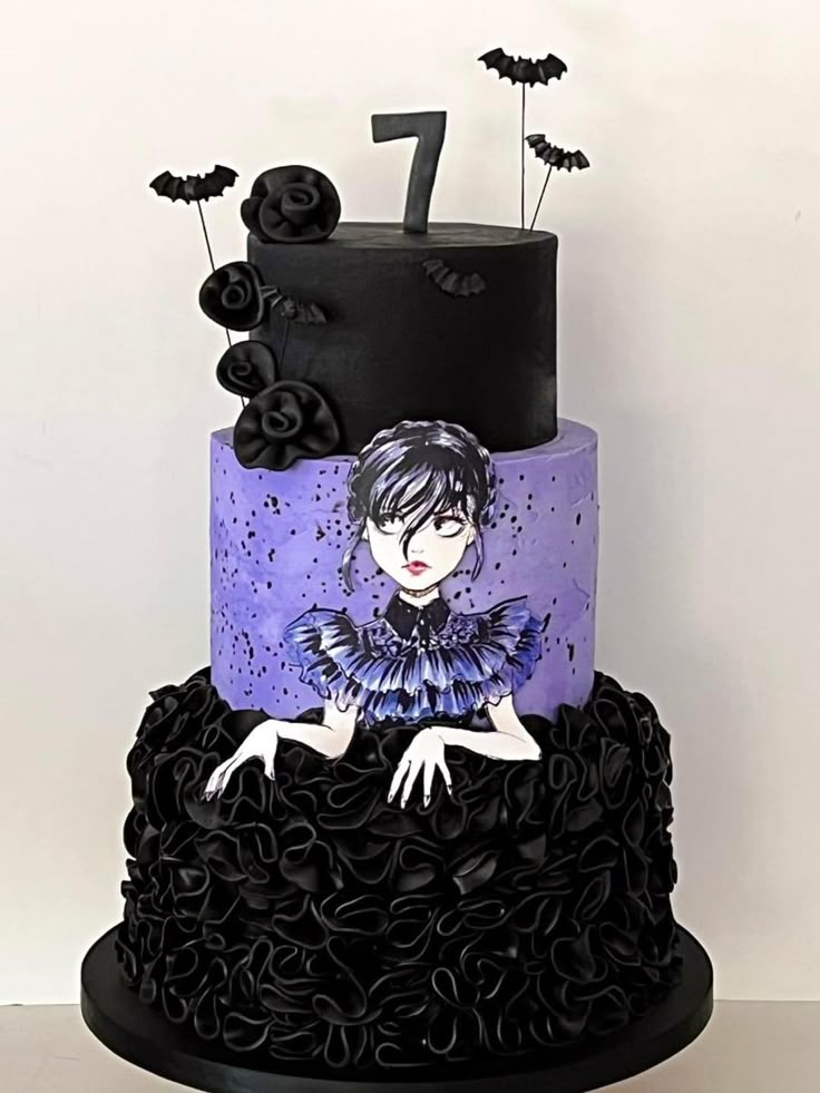 a three tiered cake decorated with black ruffles and an image of a woman