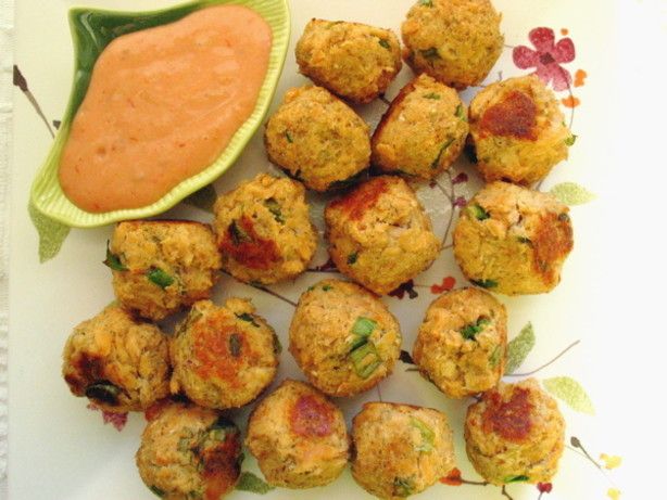 some meatballs are on a plate with dipping sauce