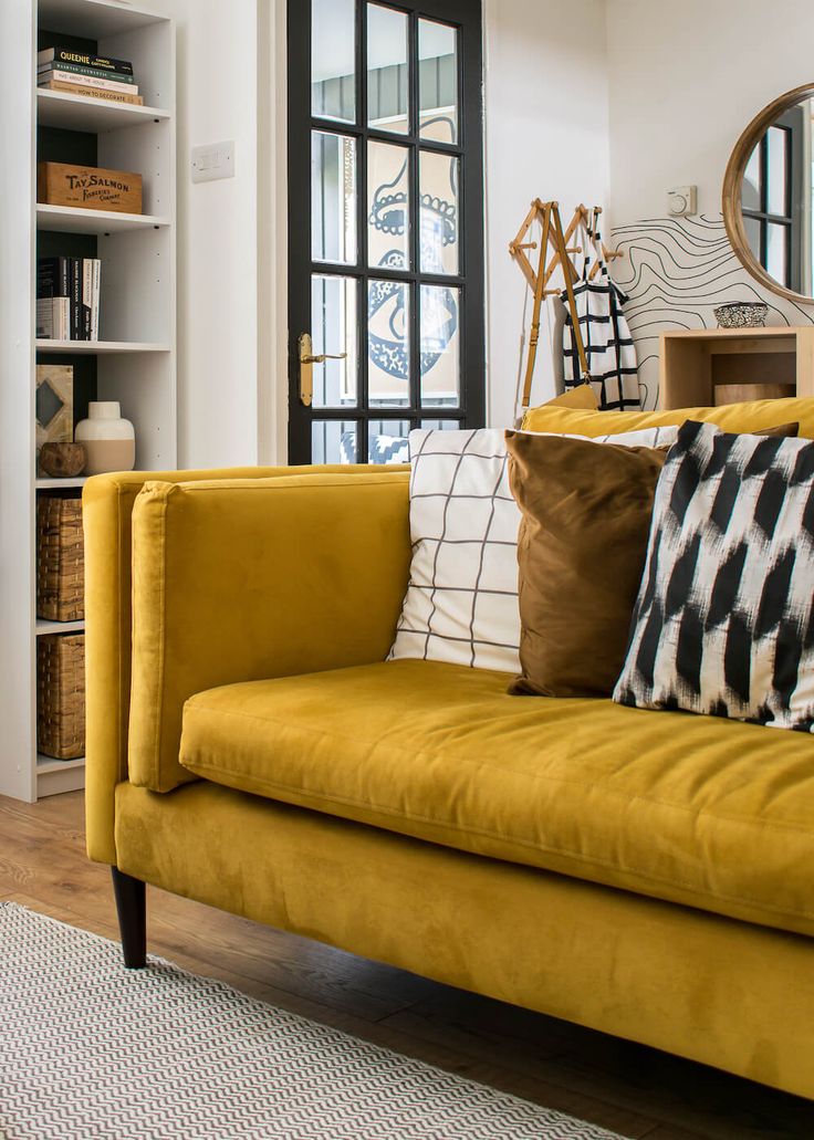 a living room with yellow couches and pillows