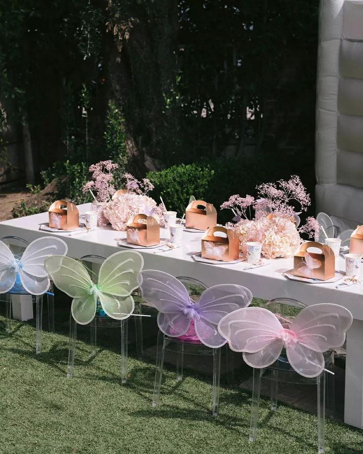 a long table covered in lots of different colored butterfly shaped chairs next to each other