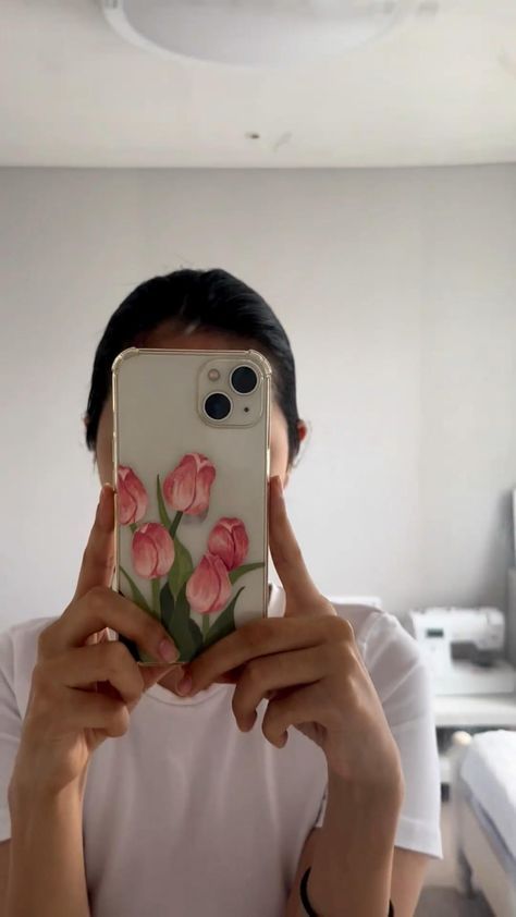 a person taking a selfie in front of their cell phone with flowers on it