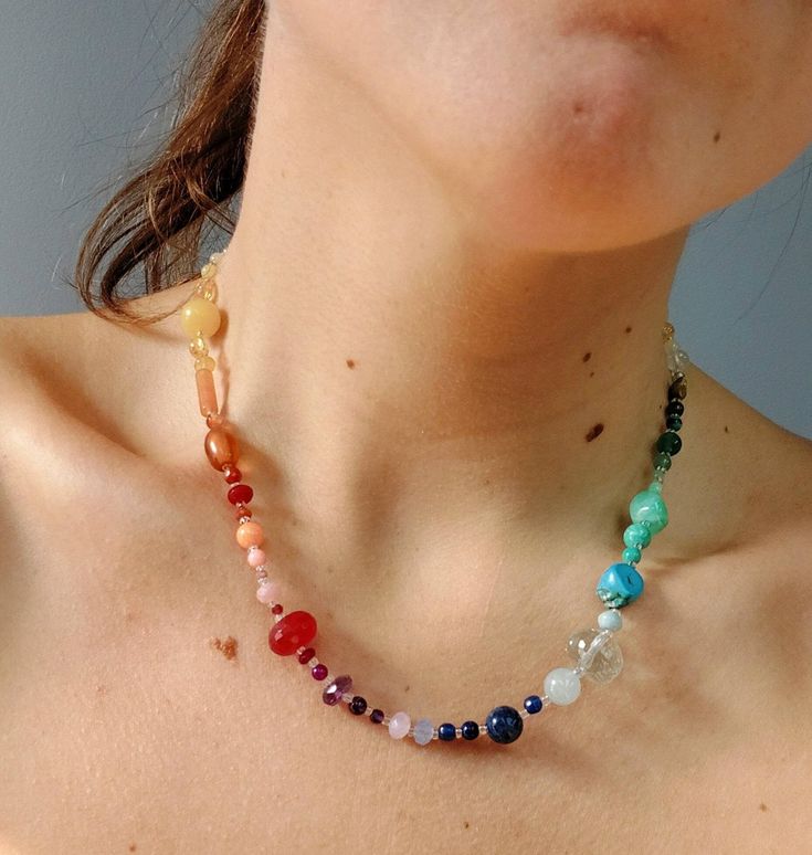 a woman wearing a multicolored beaded necklace on her chest and neckline