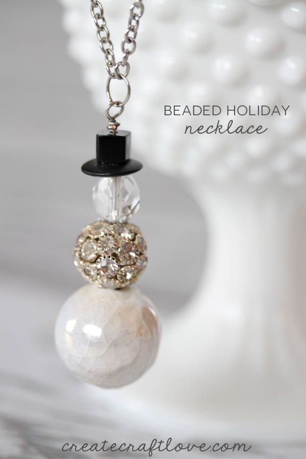 a beaded holiday ornament necklace with a top hat on it's neck