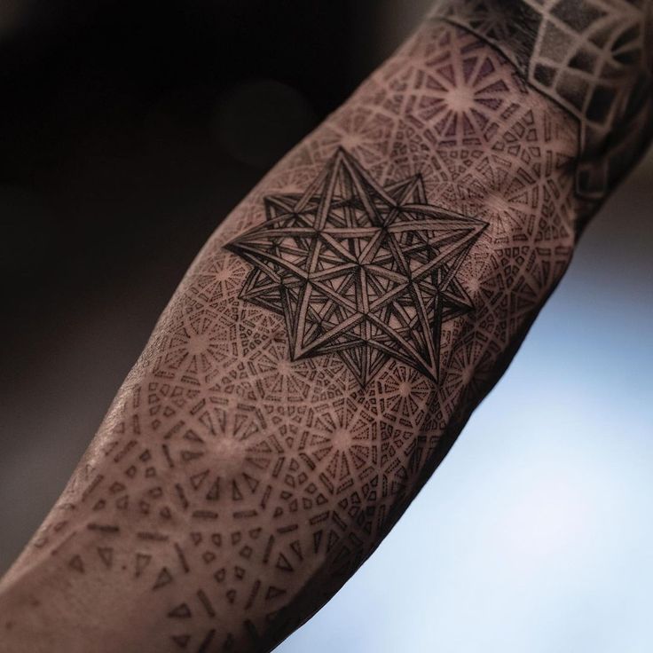 a man's arm with an intricate tattoo design on it