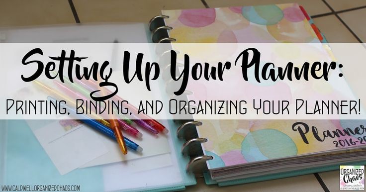 an open planner sitting on top of a tiled floor next to markers and pencils