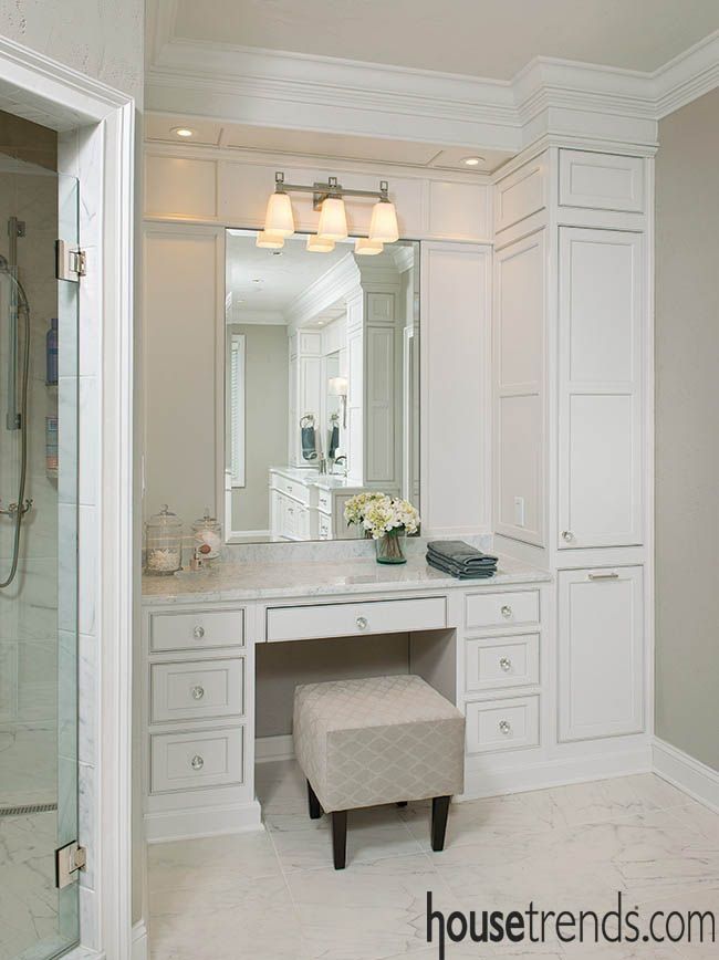 a large bathroom with white cabinets and marble counter tops, along with a stool in front of the vanity