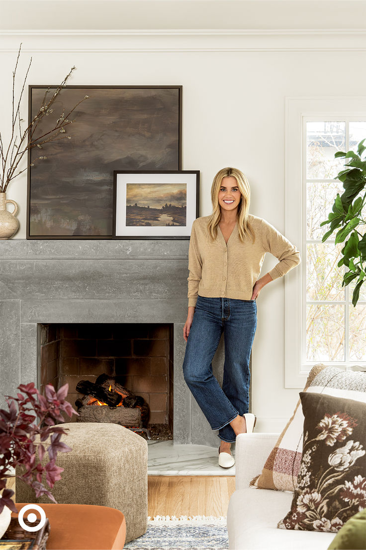 a woman standing next to a fire place in a living room