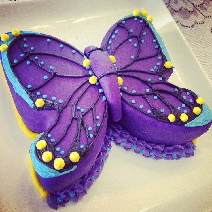 a purple butterfly cake sitting on top of a white plate