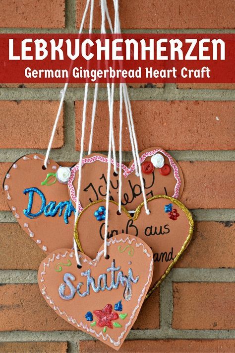 two hearts hanging on a brick wall with the words german gingerbread heart craft attached to it