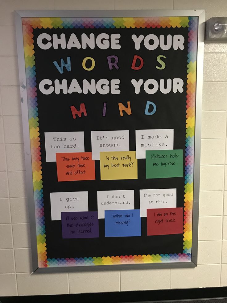 a bulletin board that says change your words to change your mind in front of a white tiled wall