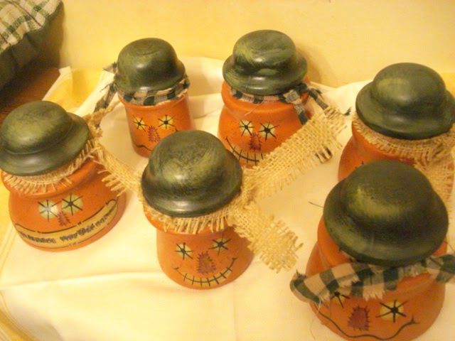 six jars with green lids are sitting on a white tablecloth and some plaid pillows