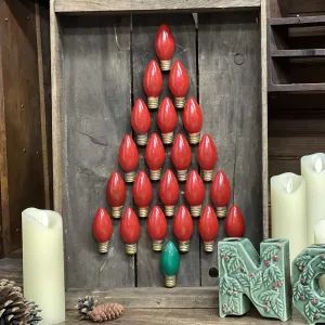 a christmas tree made out of candles in a wooden box with other items around it