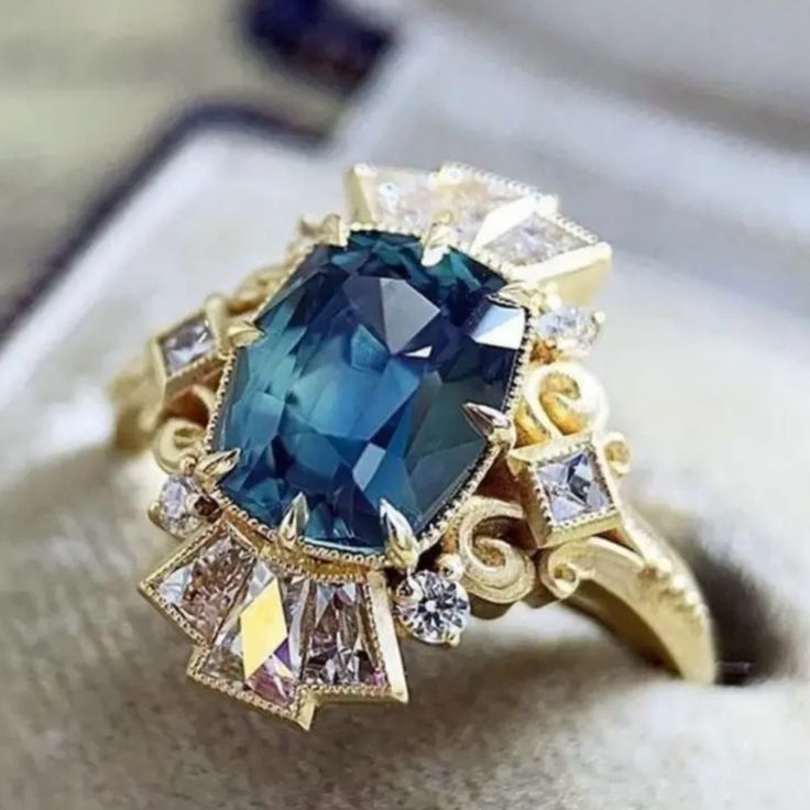 a blue ring with white and yellow diamonds on it's side, sitting in a box