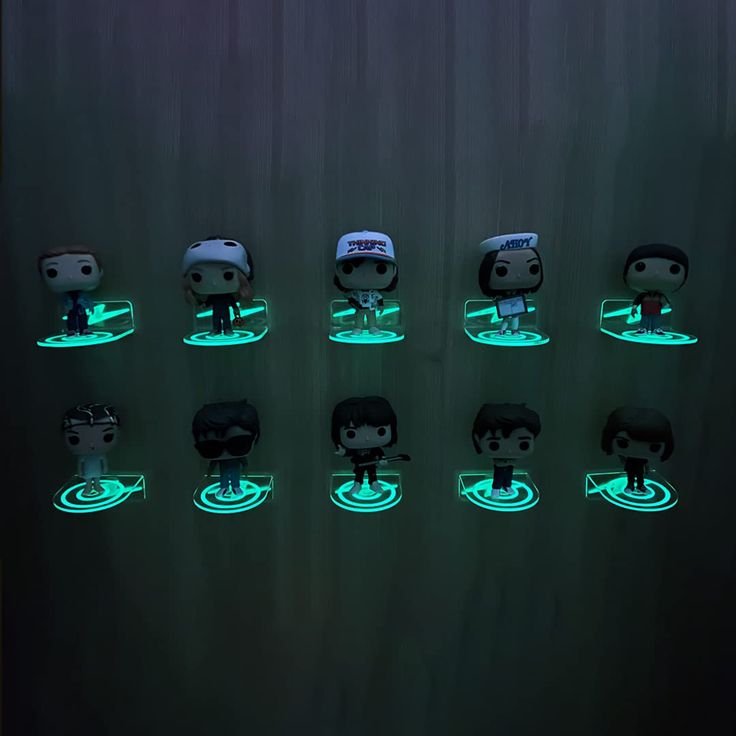 many pop vinyls are glowing in the dark with green light around them and on top of each other