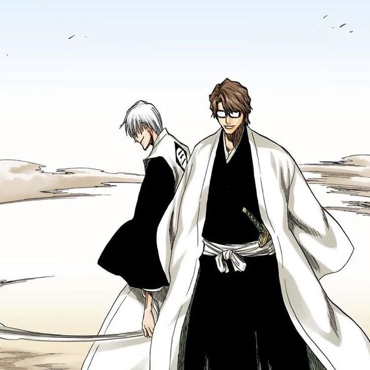 two people in black and white outfits standing on the beach with one person wearing a kimono