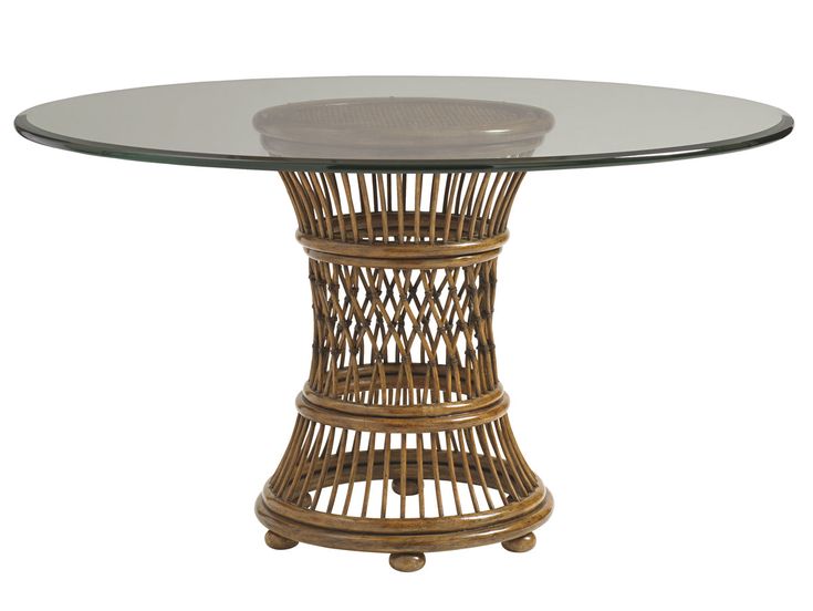 a round table with glass top and wicker base