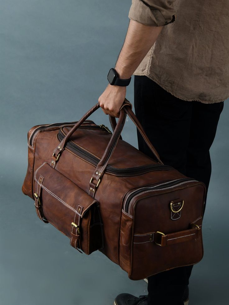 Trustpilot This is one perfect solution for all your needs. This leather duffle bag has four big pockets in the exterior with two buckles. This leather duffle bag is made of genuine goat leather which gives it a rustic look which is for everyone who is looking for something heavy-duty but with good looks. This leather bag has three compartments, one big compartment for all your clothes and shoes, two small compartments with a zipper for all of your accessories. A perfect one for every situation Leather Duffle Bag Men, Leather School Bag, Leather Briefcase Men, Leather Billfold, Leather Weekender Bag, Leather Weekender, Luggage Bags Travel, Leather Rucksack, Leather Duffle Bag