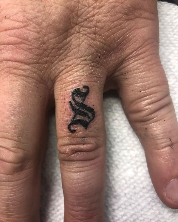 a person with a tattoo on their hand that has a snake tattooed on the middle finger