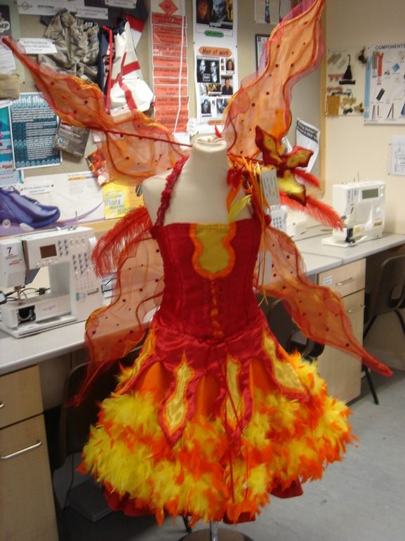 a dress made out of fire is on a mannequin in an office cubicle