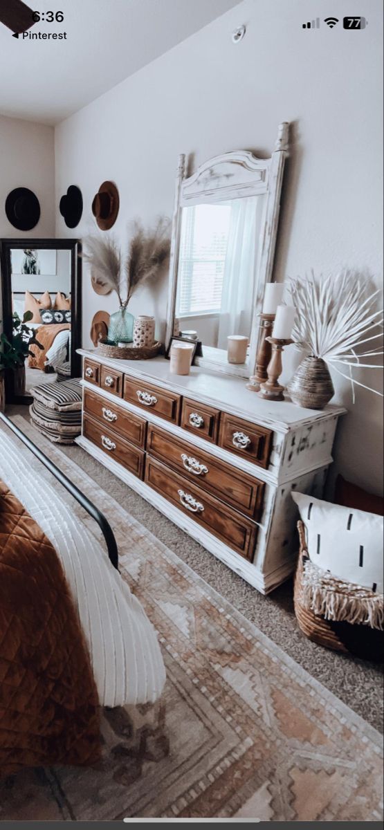 a bed room with a neatly made bed next to a dresser and large mirror on the wall